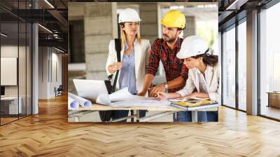 Two female inspectors and architects discuss with head engineer about construction project. Wall mural