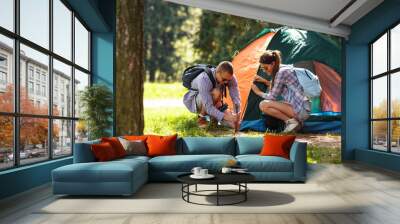 Young campers setting up the tent at the forest. Wall mural