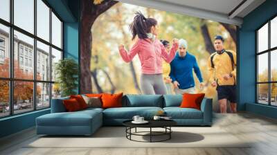 Young people jogging at the park.Female on the front.Autumn.Grain effect added for artistic impression. Wall mural