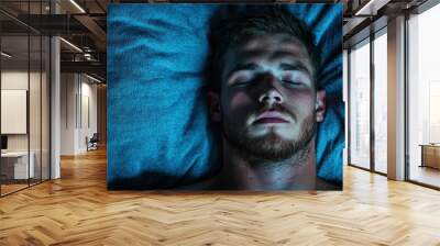 man sleeping peacefully on blue bedding Wall mural