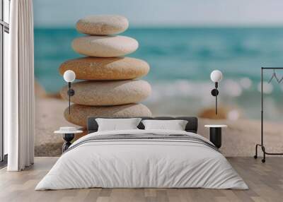 Stacked zen stones on beach with ocean in background Wall mural