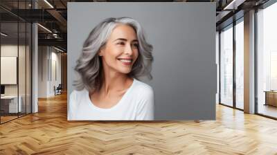 Portrait adult woman, graced with short silvery hair, healthy skin and warmth smile on gray banner background with copy space. Concept skin care, beautiful and glowing aging Wall mural