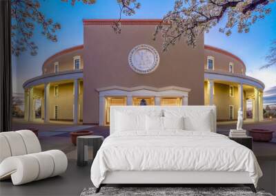 Illuminated New Mexico State Capitol at dusk with blue sky with glowing lights coming from windows. Wall mural