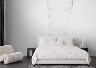 Water and ice in a boot glass on white background Wall mural