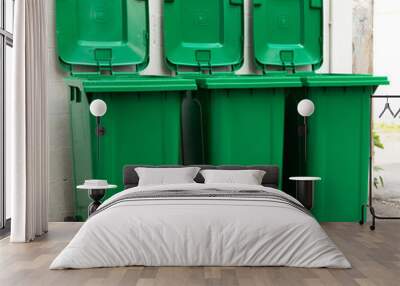 a new unbox green large bins ready to use on footpath and white concrete wall Wall mural