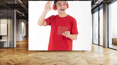 A young and handsome Asian teen man with brach wearing red headphones and holding tablet computer while use right hand to greeting someone. Isolated on white background Wall mural