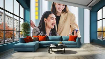 Asian beautiful young happy cheerful professional successful female businesswoman employee colleague in formal business suit take break playing hugging together at company working desk in office hour Wall mural