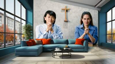 Asian man and woman are going to pray for the Lord's blessings at the Minster of Christianity. It is the routine of people who believe in Christ religion. Concept believe faith. . Wall mural