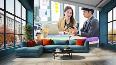 Asian young happy professional successful male and female businessman businesswoman in formal business suit sitting working talking discussing brainstorming together at workstation in meeting room Wall mural