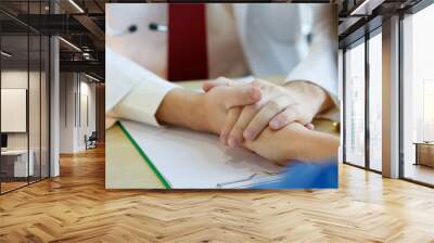 Caucasian doctor holding lady patient hand to support encouragement. Shoot photo to focus to hands Wall mural