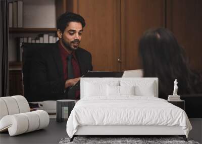 Closeup shot of Millennial Indian Asian professional successful executive bearded male businessman manager entrepreneur in formal suit sitting smiling shaking hands with businesswoman colleague Wall mural