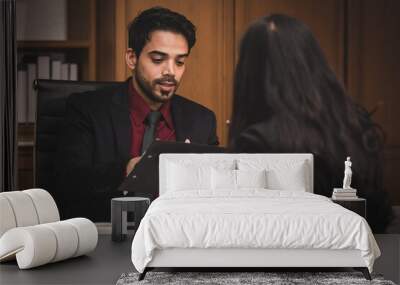 Closeup shot of Millennial Indian Asian professional successful executive bearded male businessman manager entrepreneur in formal suit sitting smiling shaking hands with businesswoman colleague Wall mural