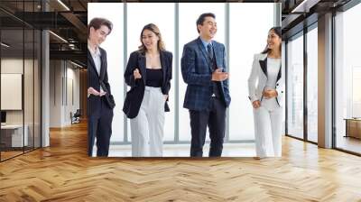 Full body shot of Millennial Asian successful professional male businessmen and female businesswomen in formal suit smiling posing look at camera walking side by side together in company hallway Wall mural