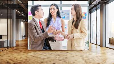 Group of millennial Asian young professional successful male and female businessman businesswoman worker employee in formal business suit standing discussing brainstorming together in company office Wall mural