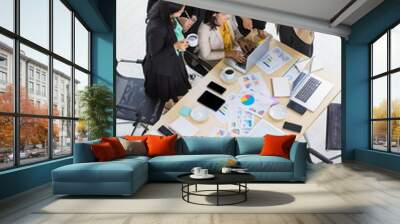 High view of one business woman working on laptop and five business woman surrounding her looking at laptop in meeting room. Concept for business meeting Wall mural