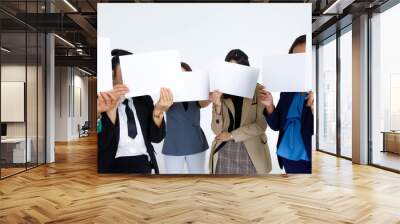 Studio shot of incognito unidentified unrecognizable faceless group of female office staff in business wears stand hold blank empty paper sign cover face for advertisement text on white background Wall mural