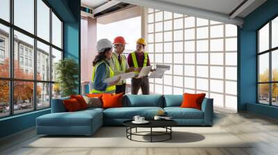 Three Asian engineers team, two men and one woman working together in an outdoor construction site Wall mural