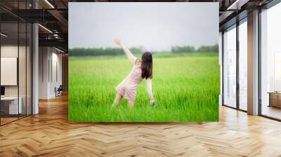 Girl, standing, looking at a green field , Beautiful natural background Wall mural