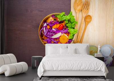 Delicious fruit salad in a clay brown dish on a cutting board with two dessert forks, mint leaves, on an old wooden table, close-up, top view Wall mural