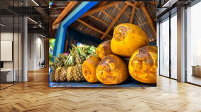 Close up of raw yellow and green water coconuts on the counter of a fruit shop in the tropical island. Fresh juice and vitamins for a healthy lifestyle on summer vacation Wall mural