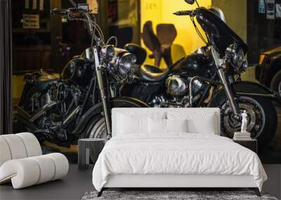 Two black chopper motorcycles. Bikes are parked in the parking lot. Chrome wheels and motor. Glitter from the lights on the details Wall mural