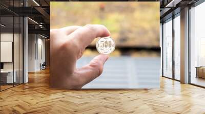 Man hold japanese coin 500 yen on blurred background Wall mural