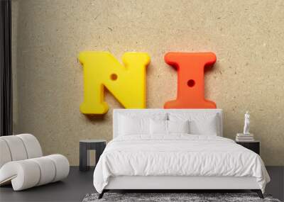 Plastic alphabet letter in word NI (Abbreviation of net income, no idea, national insurance or nursing informatics) on wood background Wall mural