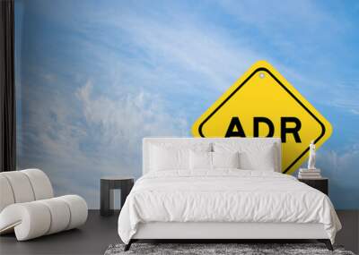 Yellow transportation sign with word ADR (Abbreviation of adverse drug reaction) on blue color sky background Wall mural