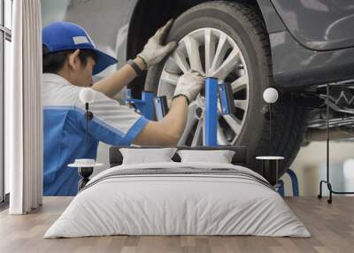 mechanic repairman making tyre fitting screwing out a wheel nipple Wall mural