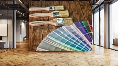 Painter and decorator work table with house project, color swatches, painting roller and paint brushes Wall mural