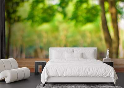 Empty wood table for product display over blur green tree garden. Blurred of nature outdoor with bokeh light background. Wall mural