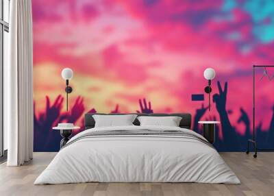 A vibrant sunset captures a crowd with hands raised, symbolizing excitement and unity at a concert or event. Wall mural