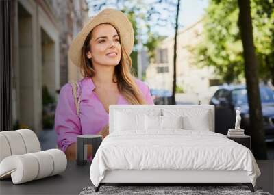 A Woman looks around while exploring the city using her smartphone Wall mural