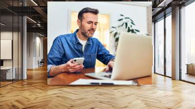 Adult man at home doing online payment with two factor authentication on mobile phone Wall mural