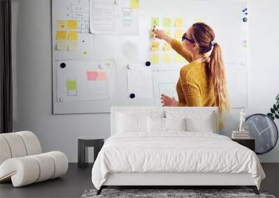 Back view of female web designer working on whiteboard in office Wall mural