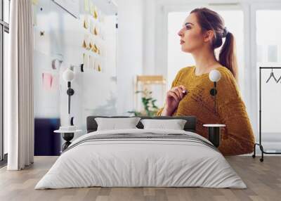 Businesswoman looking at whiteboard in office Wall mural