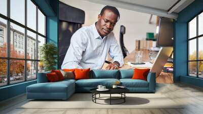 Busy young businessman calculates finances in the office Wall mural