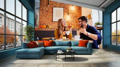 couple of young people drinking coffee and eating cake in a stylish modern cafeteria Wall mural