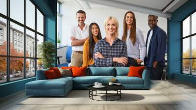 Group portrait of female entrepreneur with group of colleagues standing together at office Wall mural