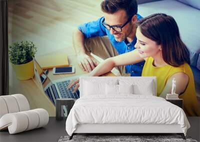 Happy couple doing online shoping together at home Wall mural