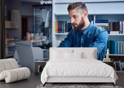 Hipster, designer working on laptop in office Wall mural