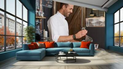 Man preparing coffee in his coffee shop business Wall mural