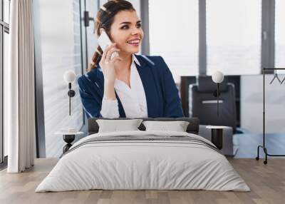 Portrait of beautiful business woman talking on phone at office Wall mural