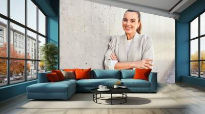 Portrait of beautiful businesswoman leaning against concrete wall Wall mural