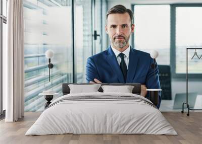 Portrait of businessman standing with arms crossed in modern office Wall mural