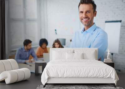 Portrait of cheerful business man standing in modern office with Wall mural