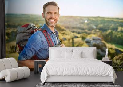 Portrait of cheerful man with backpack during hiking trip in the mountains Wall mural