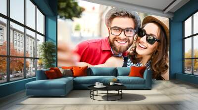 Portrait of cheerful young couple taking selfie together in the summer outdoors Wall mural