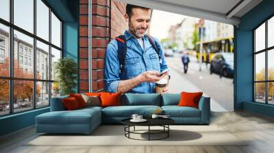 Portrait of man talking on phone through wireless headphones out in the city Wall mural