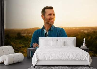 Portrait of smiling adult man on day hike during sunset Wall mural